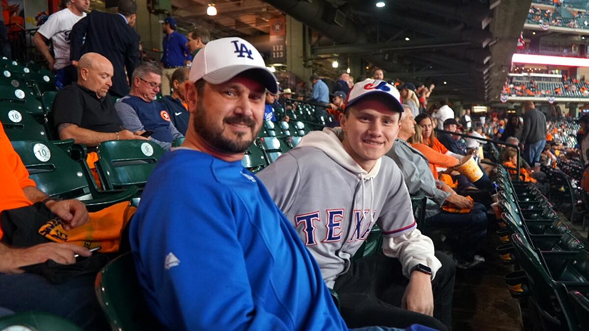 Nick Casebolt wears a Yu Darvish jersey from his Rangers days while taking in Game 3 with his father, Derek.