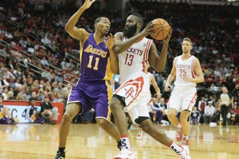 Houston Rockets guard James Harden tries to drive past Lakers forward Wesley Johnson.