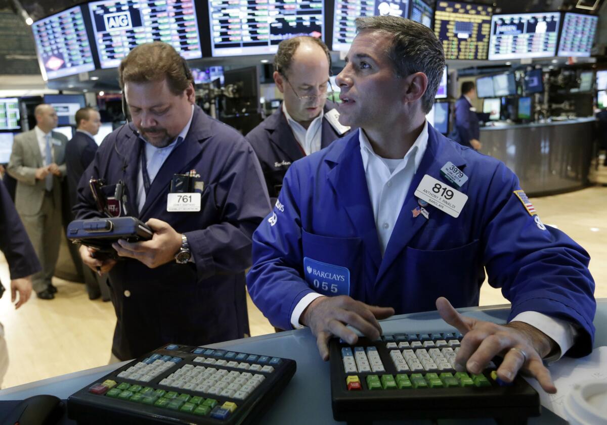 Anthony Rinaldi, right, works with traders on the floor of the New York Stock Exchange.