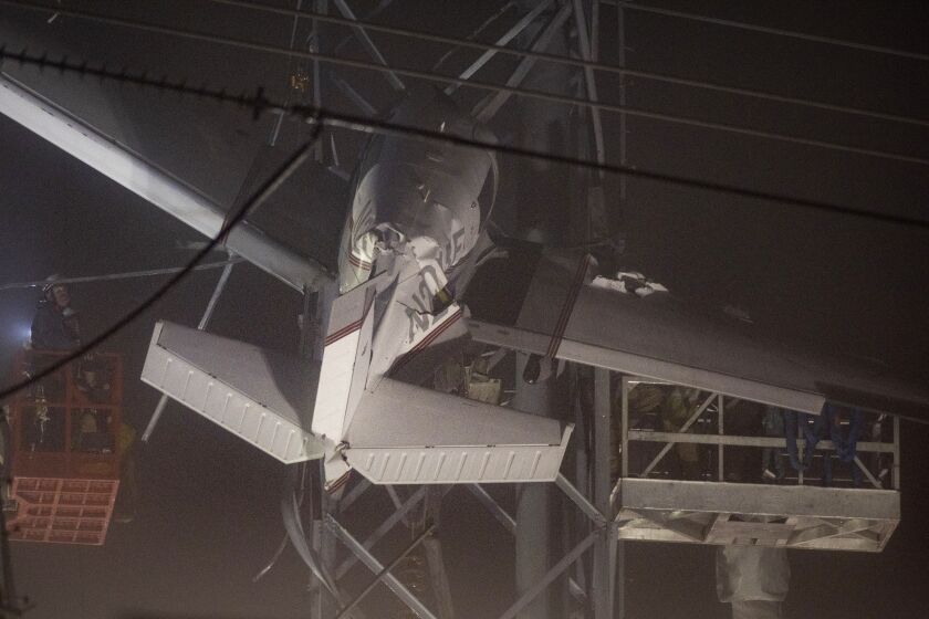 First responders work to rescue aircraft passengers after the small plane crashed and became stuck in live power lines, Monday, Nov. 28, 2022, in Montgomery Village, a northern suburb of Gaithersburg, Md. Both occupants were successfully rescued. (AP Photo/Tom Brenner)