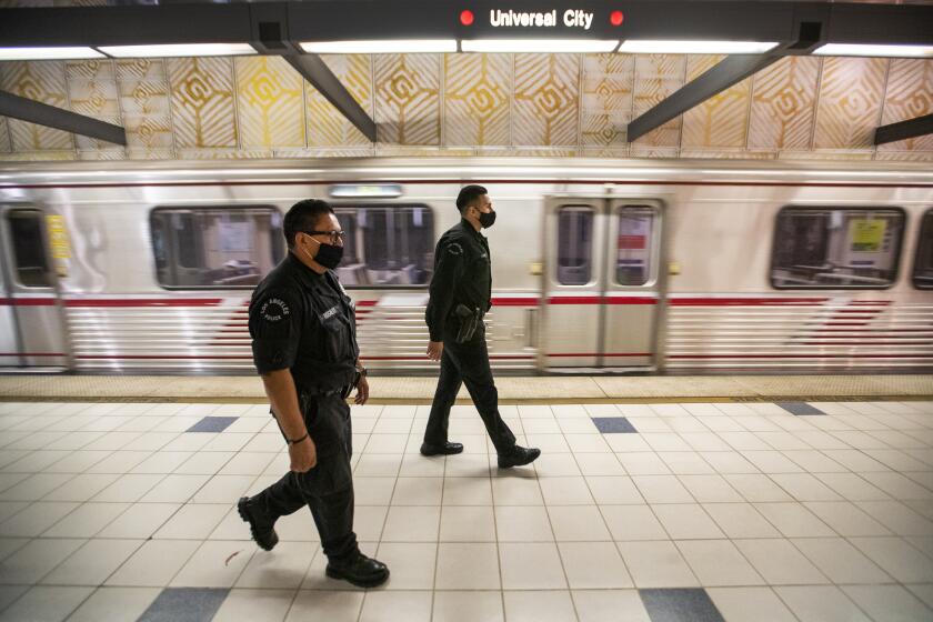 HOLLYWOOD, CA - JUNE 25: LAPD officers E. Rosales, left, and D. Castro, patrol the Metro Red Line at the Universal City Metro Station Thursday, June 25, 2020 in Hollywood, CA. The Metro Board of Directors held a meeting Thursday where the agenda included the consideration of appointing a committee to develop plans for replacing armed transit safety officers with ``smarter and more effective methods of providing public safety.'' Metro security is staffed by multiple agencies, including the L.A. County Sheriff's Department and L.A. and Long Beach police departments, transit security guards and contract security workers. (Allen J. Schaben / Los Angeles Times)