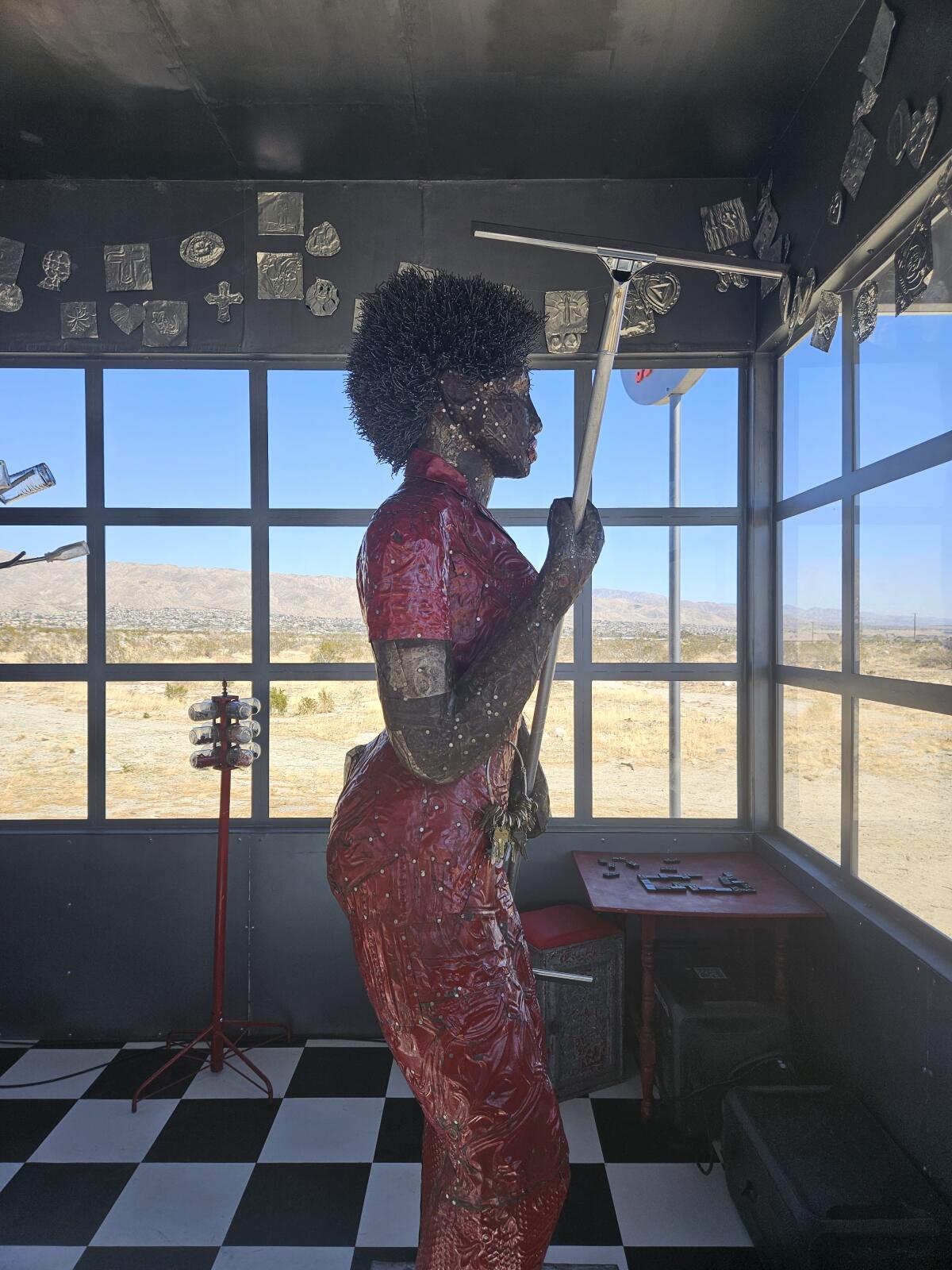 Inside Alison Saar's "Soul Service Station," an Amazon wields a squeegee
