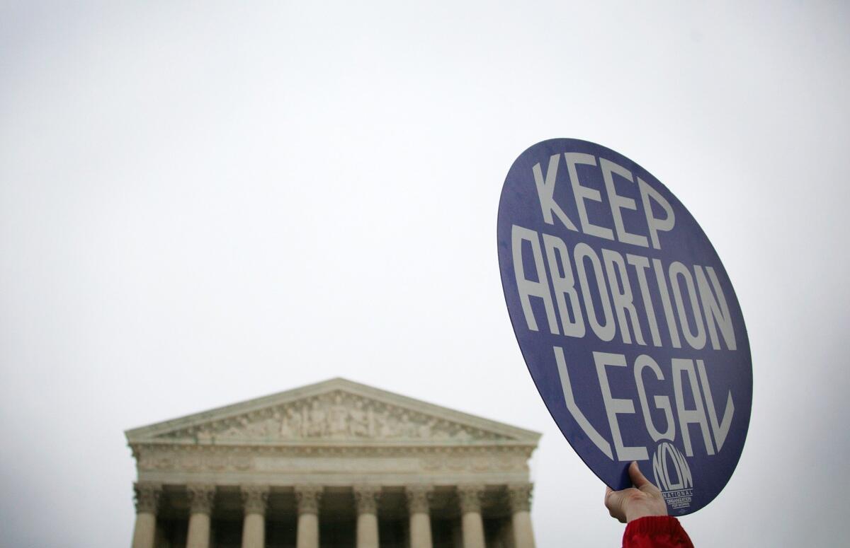 A pro-choice demonstrator holds up a placard outside the U.S. Supreme Court in Washington, D.C.