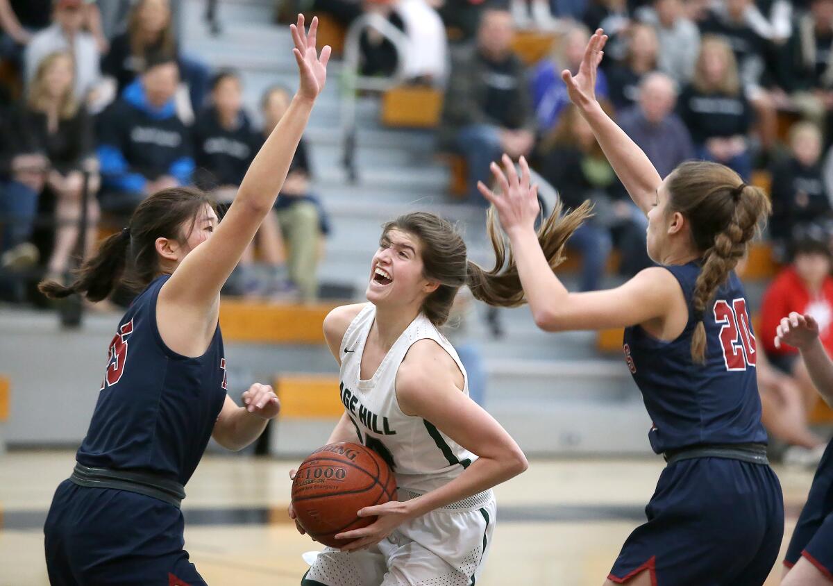 Sage Hill’s Isabel Gomez drives in for a layup between St. Margaret’s defenders Jacklyn Mok, left, and Patricia Baena in a San Joaquin League game on Tuesday.
