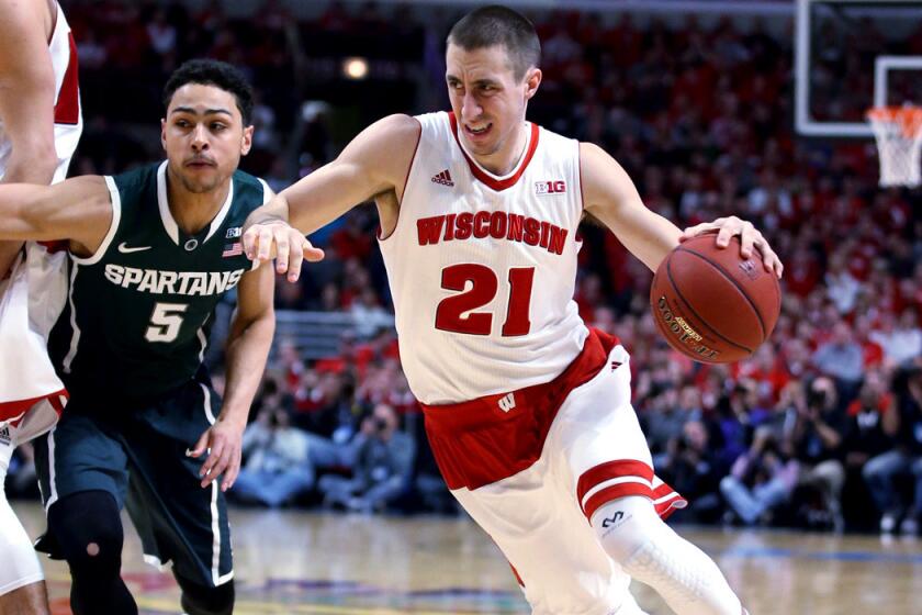 Wisconsin's Josh Gasser drives on Michigan State's Bryn Forbes during the first half of the Big Ten Conference tournament championship on Sunday.