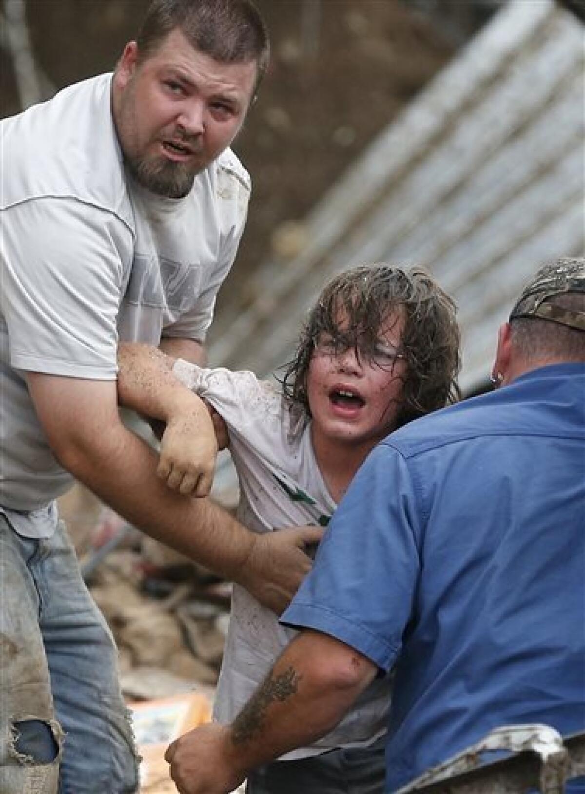 A child is pulled from the rubble of Plaza Towers Elementary School after a tornado in Moore, Okla.