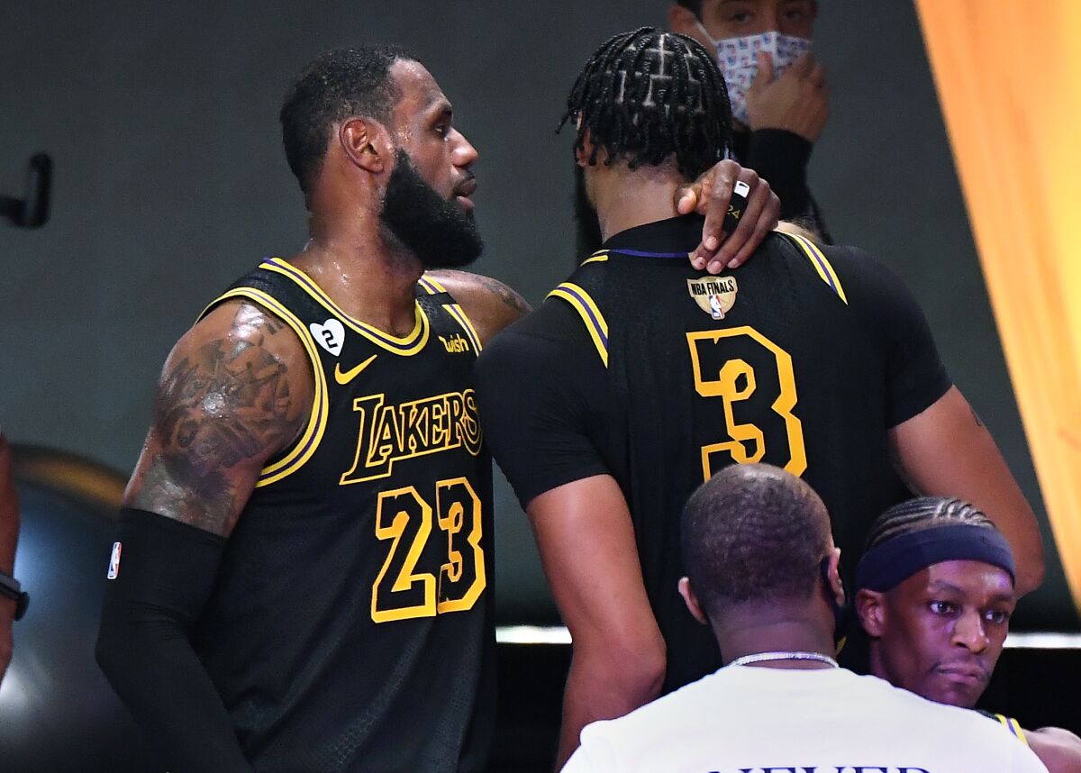 The Lakers' LeBron James, left, talks with Anthony Davis after the Game 2 win over the Miami Heat in "Black Mamba" jerseys.