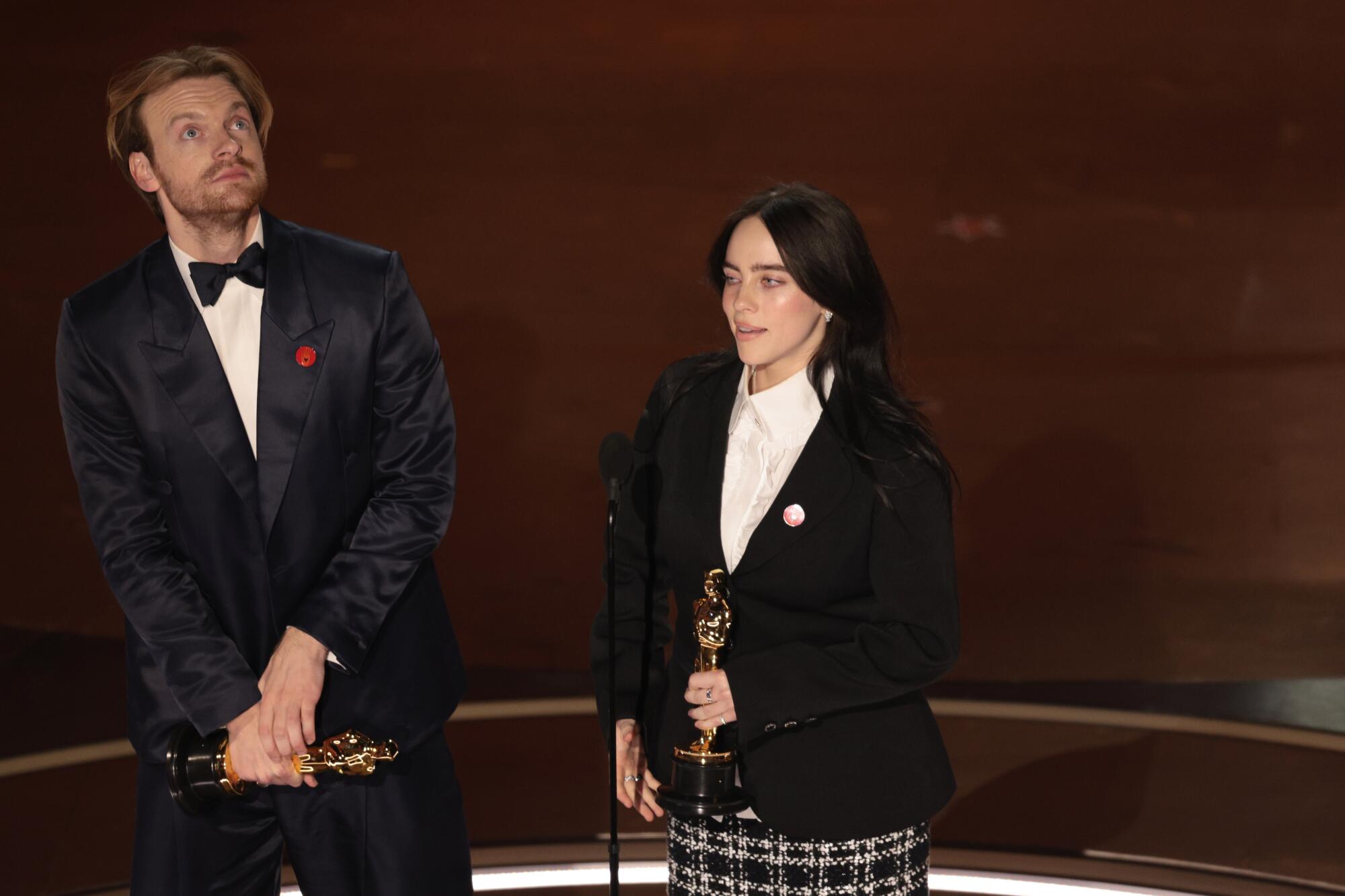 Finneas O'Connell and Billie Eilish at the mic on the Oscars stage.