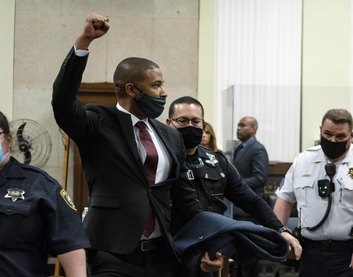 Jussie Smollett raises his fist as he is led out of the courtroom 