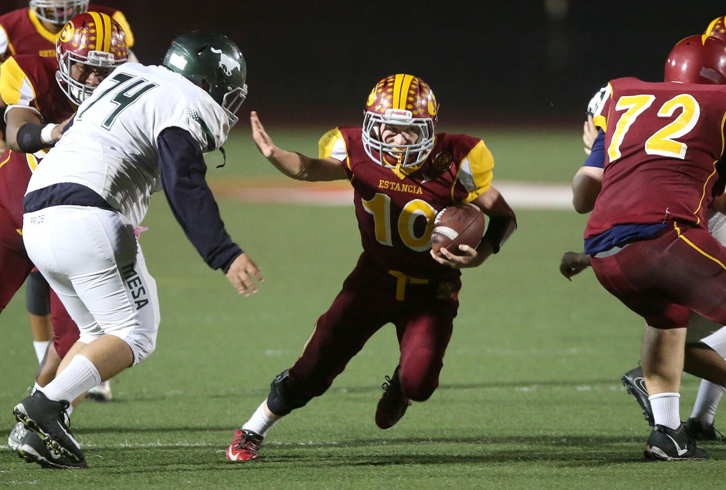 Estancia High's Trevor Pacheco runs through a hole en route to a touchdown in the second quarter of the Battle for the Bell game against rival Costa Mesa at Jim Scott Stadium on Friday.