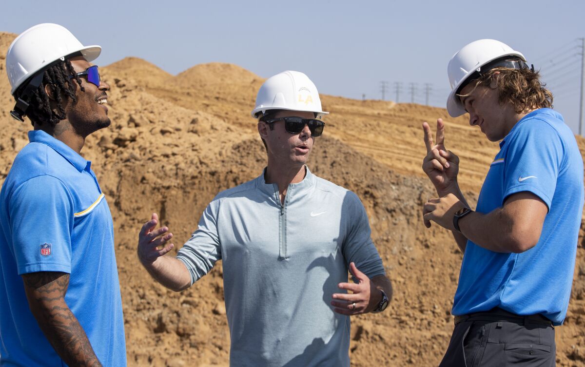 Derwin James Jr., left, coach Brandon Staley and Justin Herbert chat during a groundbreaking ceremony in El Segundo.