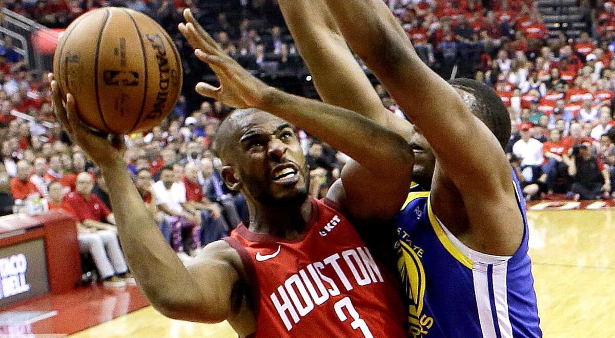 Rockets guard Chris Paul drives to the basket against Warriors center Kevon Looney during the first half of Game 3.