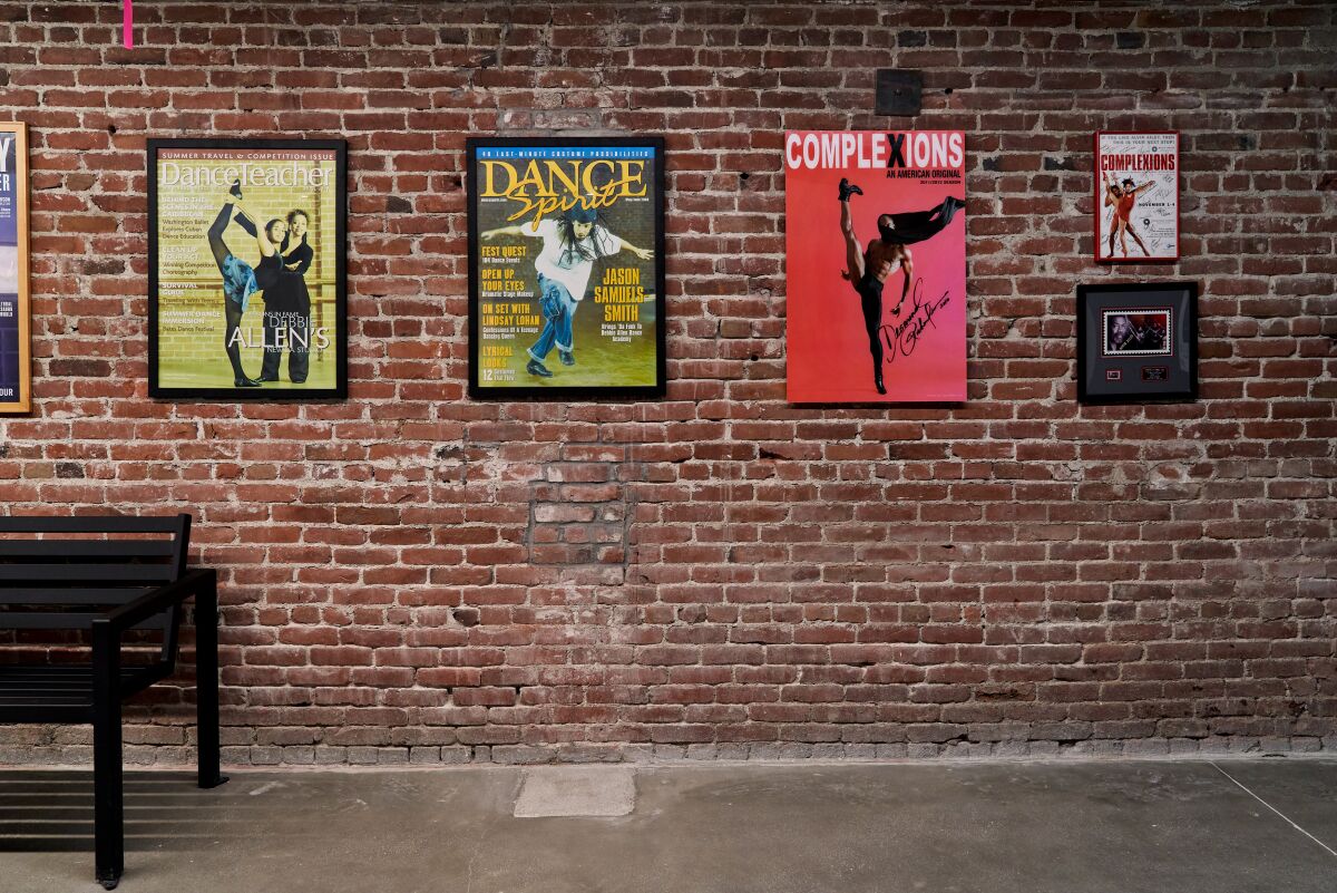 Posters are displayed on a brick wall