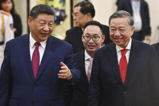 Vietnam's Communist Party General Secretary To Lam and China's President Xi Jinping walk together.