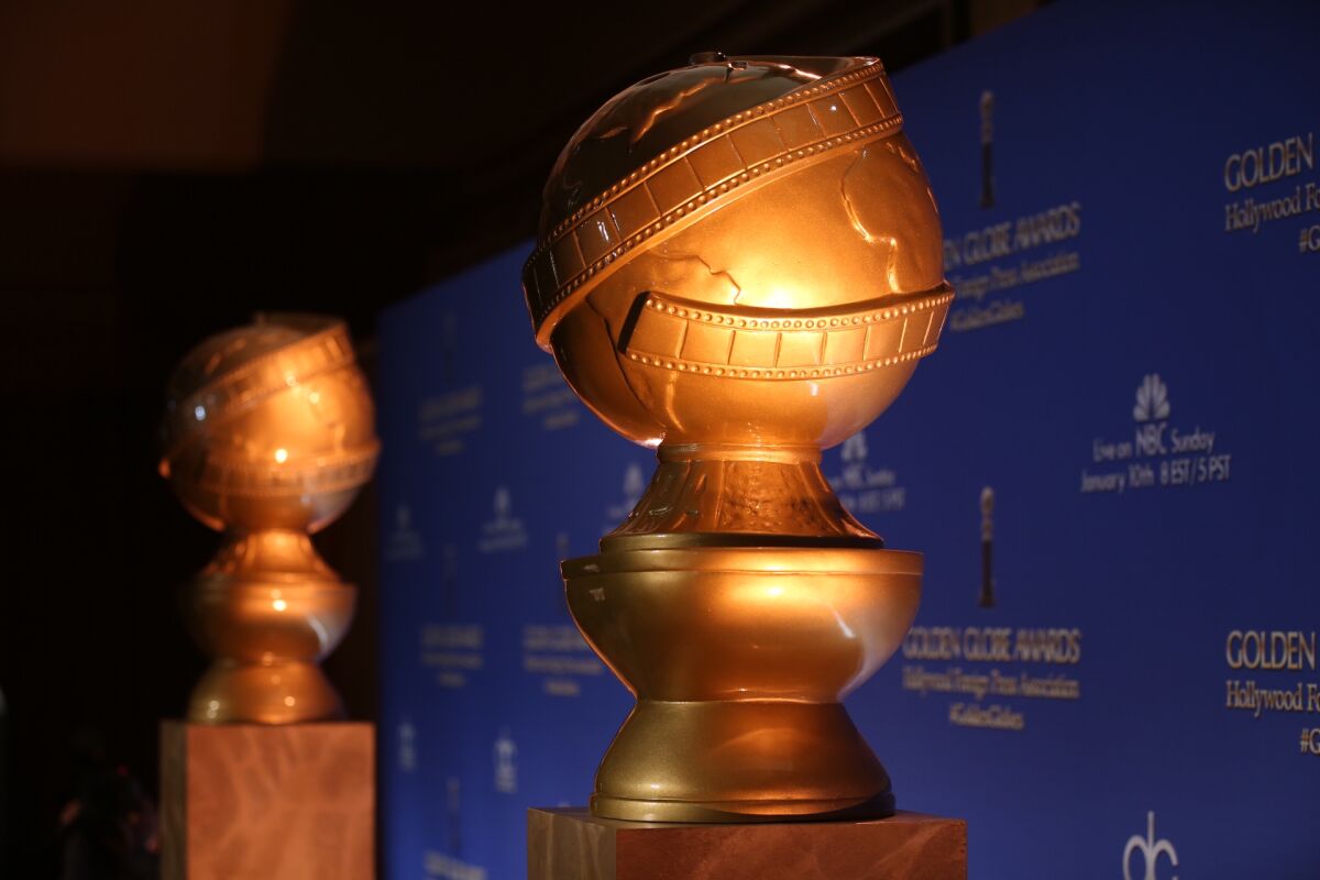A pair of oversize Golden Globe statue decorations