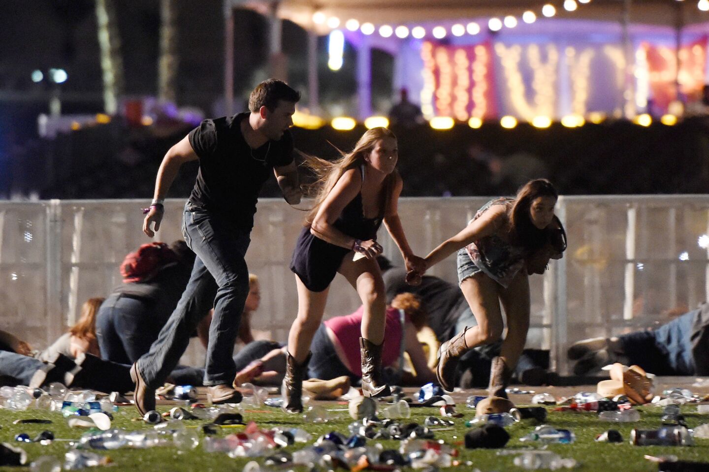 People run from the Route 91 Harvest country music festival after hearing gunfire Sunday night in Las Vegas. The shooter was firing from the Mandalay Bay Resort and Casino.