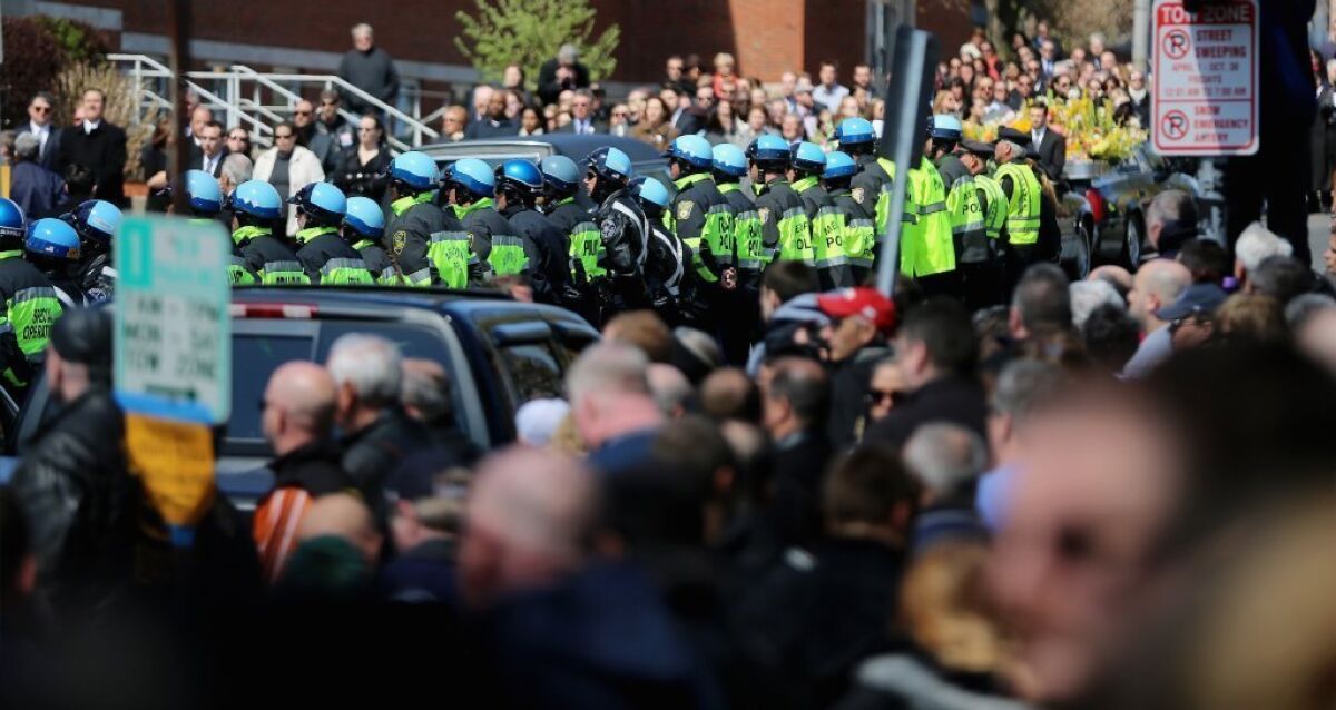 Police officers and others gather on Monday outside the funeral for 29-year-old Krystle Campbell, one of three people killed in the Boston Marathon bombings, in Medford, Mass.
