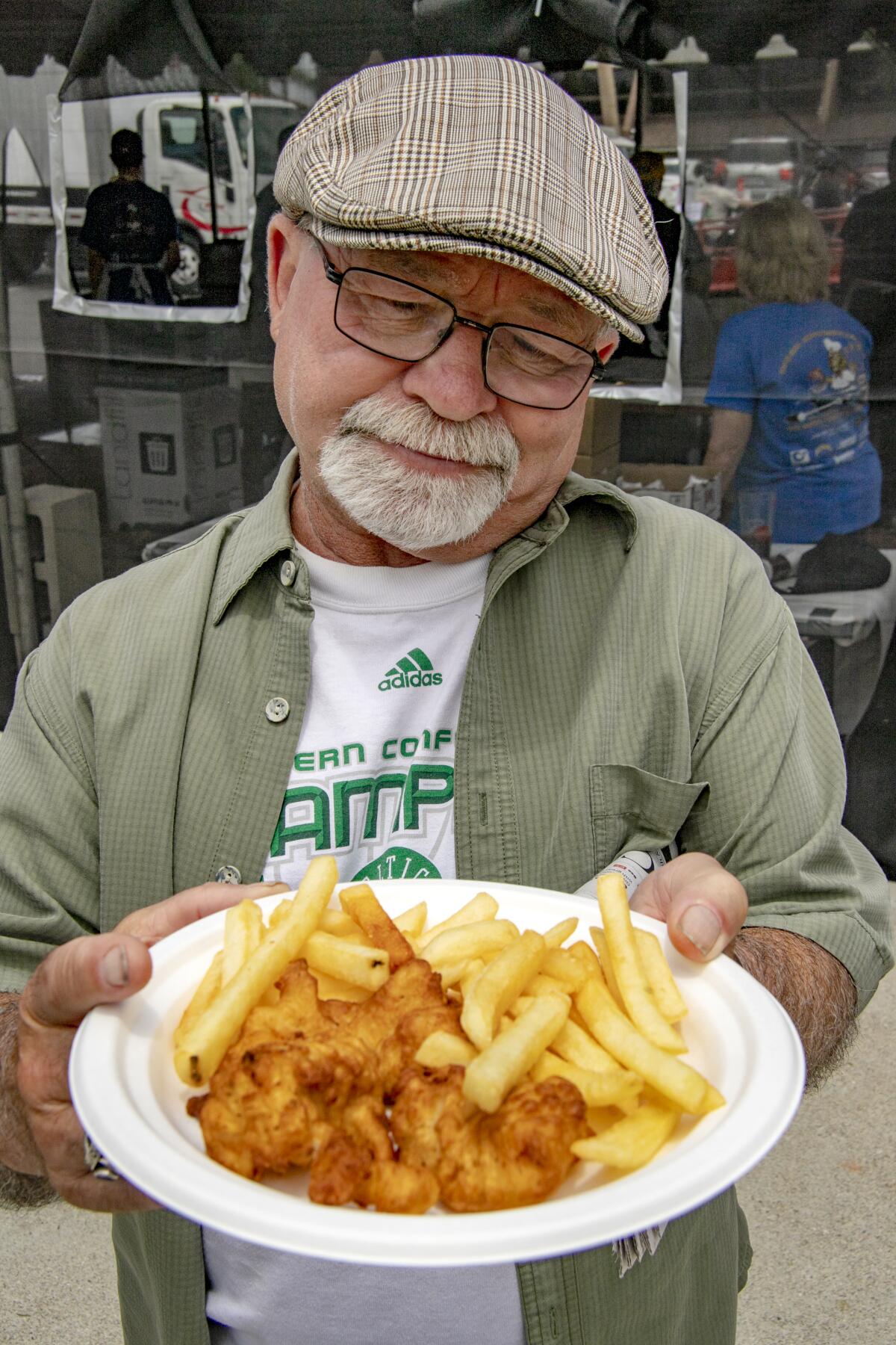 A quizzical Ron Morse contemplates his $15 fish dinner Saturday at the Fish Fry at Lions Park in Costa Mesa, June 4, 2022.