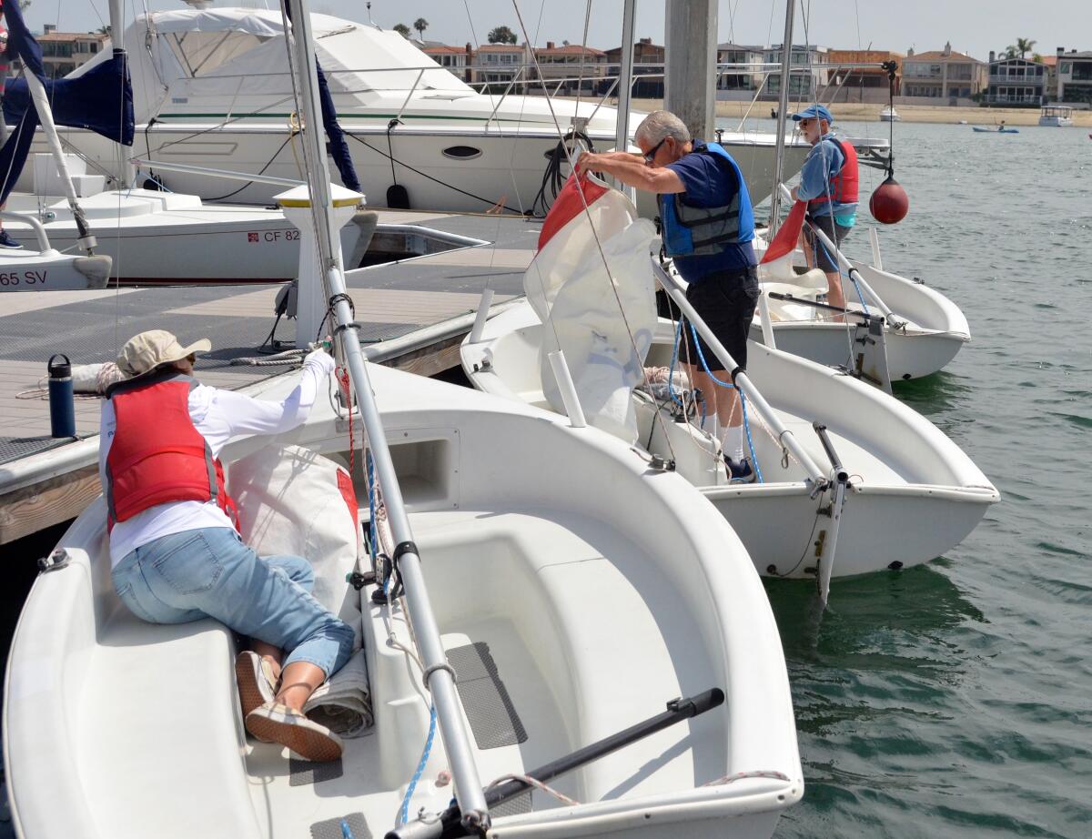 From left, Ingrid Vallejo, Art Adair and Rick MacMahon rig their individual Lido 14 sailboats.