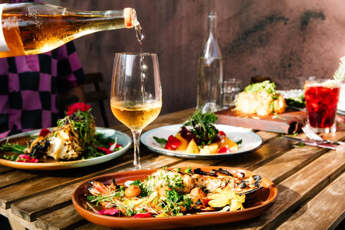 Guests enjoy dinner on the outdoor patio space at Le Great Outdoor.