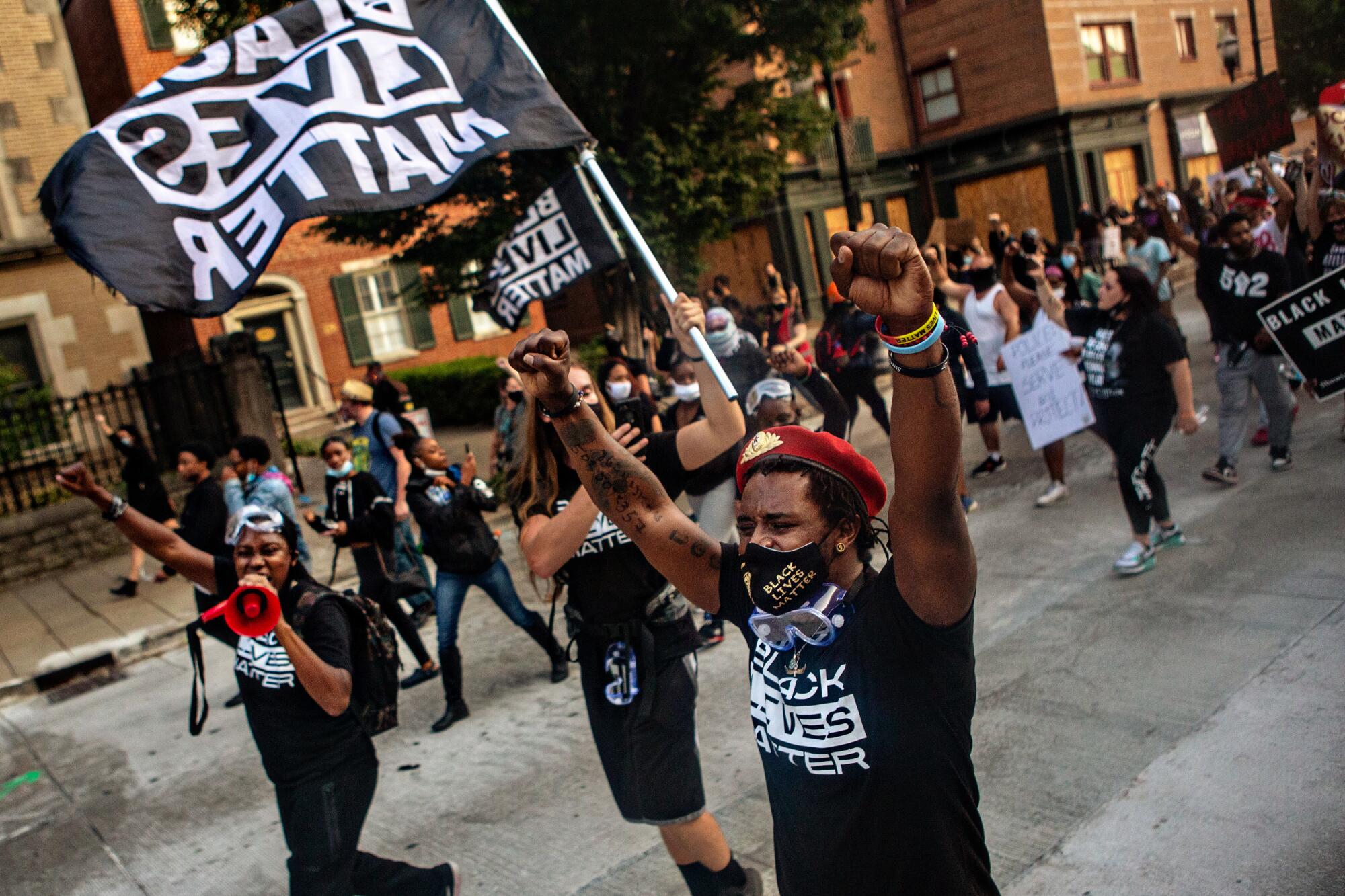 A woman leads the crowd in chants as hundreds of demonstrators protest.