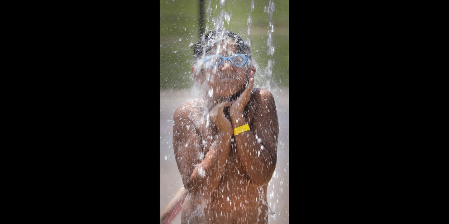 With the temperature approaching 100 degrees at 2:30 pm in the Sprayground at Santee Lakes, nine-year-old Elias Alcorta of Lakeside cooled off from the heat.