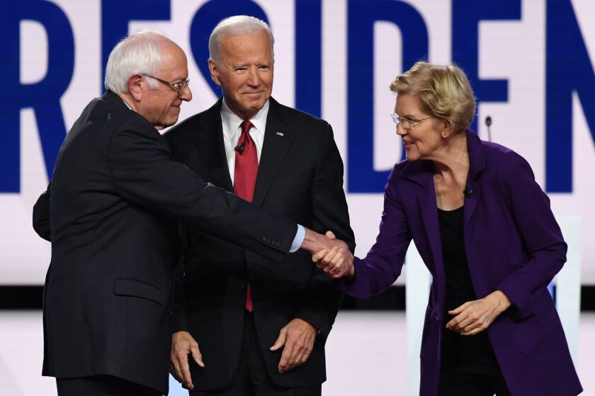 Democratic presidential hopefuls Vermont Senator Bernie Sanders (L) and Massachusetts Senator Elizabeth Warren greet each other onstage next to former Vice President Joe Biden ahead of the fourth Democratic primary debate of the 2020 presidential campaign season co-hosted by The New York Times and CNN at Otterbein University in Westerville, Ohio on October 15, 2019. (Photo by SAUL LOEB / AFP) (Photo by SAUL LOEB/AFP via Getty Images)