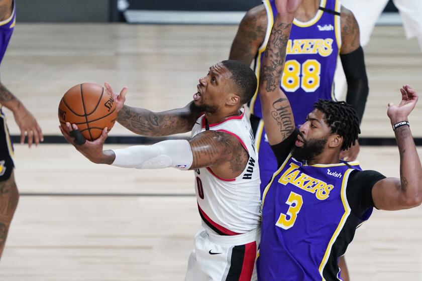Portland Trail Blazers guard Damian Lillard (0) drives to the basket past Los Angeles Lakers forward Anthony Davis (3) during the first half of an NBA basketball first round playoff game, Saturday, Aug. 22, 2020, in Lake Buena Vista, Fla. (AP Photo/Ashley Landis, Pool)
