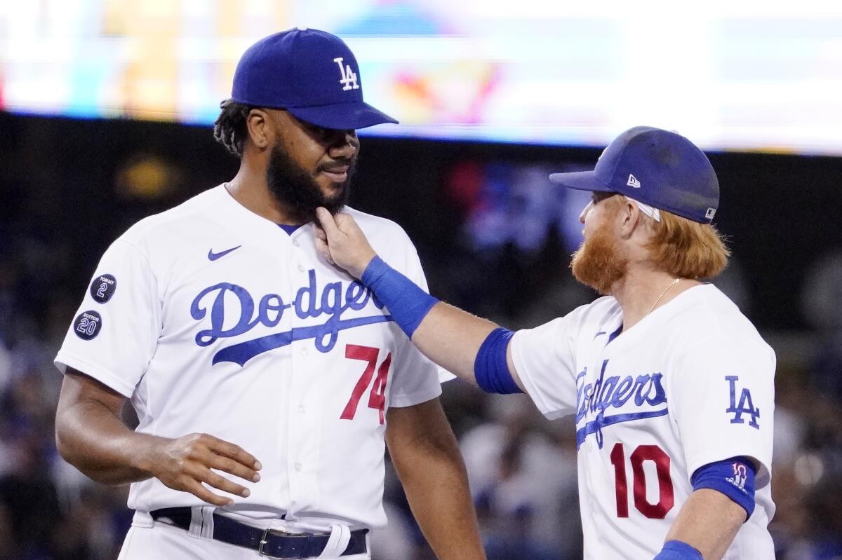The Dodgers' Justin Turner, right, playfully yanks the beard of Kenley Jansen after the Dodgers beat the Rockies 1-0.