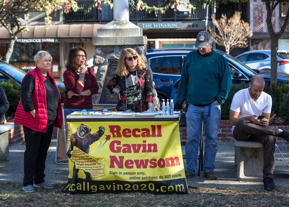 Five people stand at a table with a banner that reads "Recall Gavin Newsom."