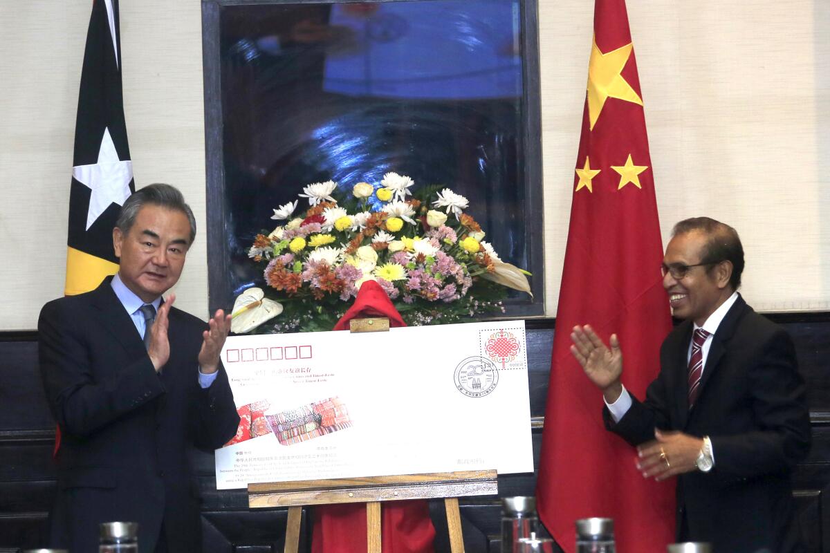 Chinese Foreign Minister Wang Yi, left, and East Timorese Prime Minister Taur Matan Ruak applaud during their meeting in Dili, East Timor, Friday, June 3, 2022. (AP Photo/Lorenio Do Rosario Pereira)