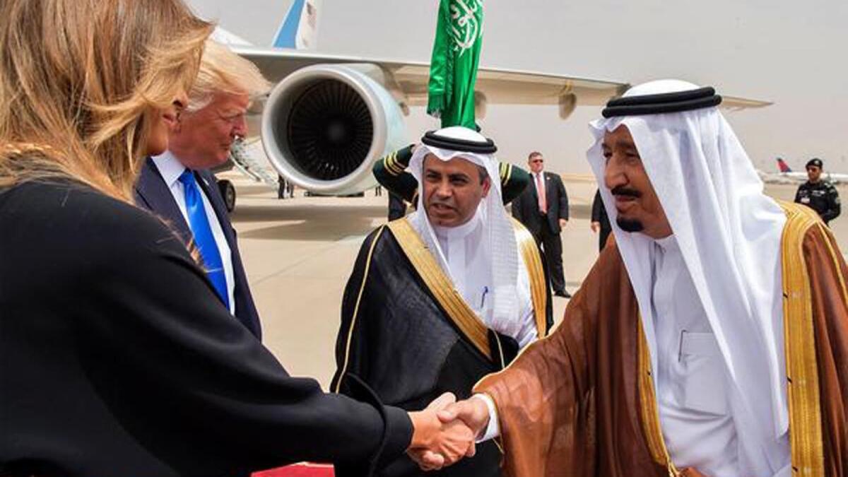 First Lady Melania Trump, standing next to President Trump, shakes hands with Saudi King Salman at King Khalid International Airport in Riyadh.
