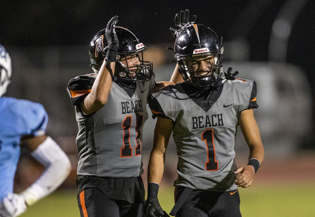 Huntington Beach's Hunter Barker, left, congratulates AJ Vandermade after he scores a touchdown against Mayfair.