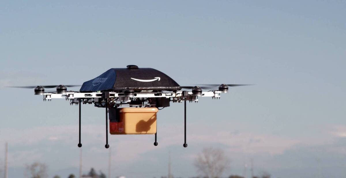 An unmanned aerial vehicle carries a package from Amazon. 