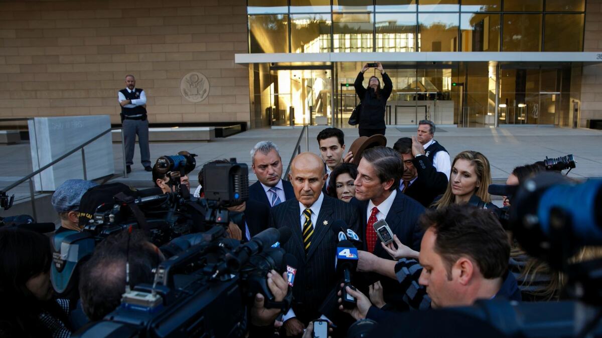 Former Los Angeles County Sheriff Lee Baca, center, talks to reporters outside court in December.