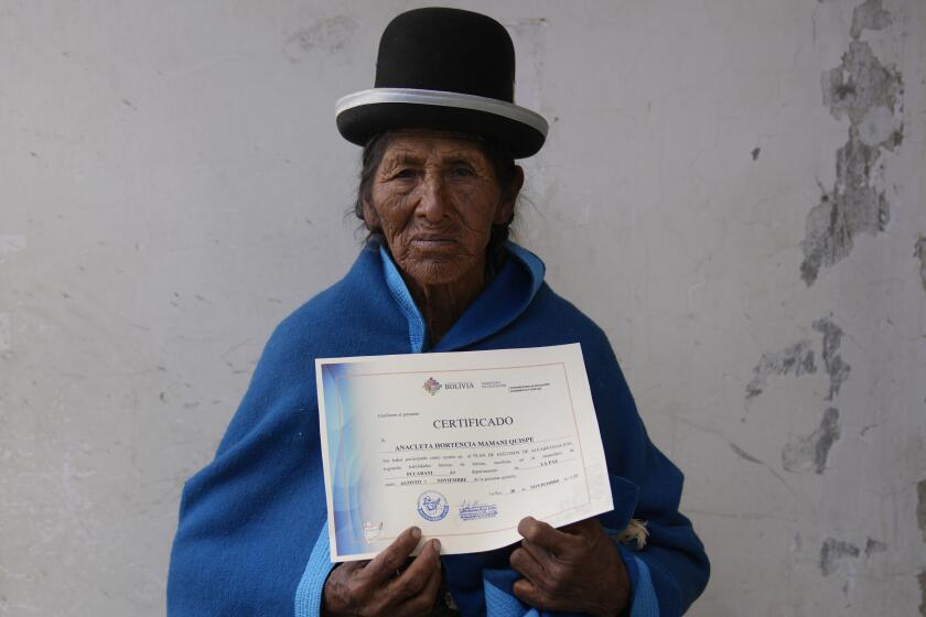 Anacleta Mamani Quispe, 71, poses for a photo after receiving her certificate during an adult literacy graduation ceremony in Pucarani, Bolivia, Sunday, Dec. 4, 2022. Mamami is among more than 20,000 senior citizens, mainly women from low-income rural communities, who have learned to read and write this year as part of “Bolivia Reads,” a government-sponsored literacy program. (AP Photo/Juan Karita)