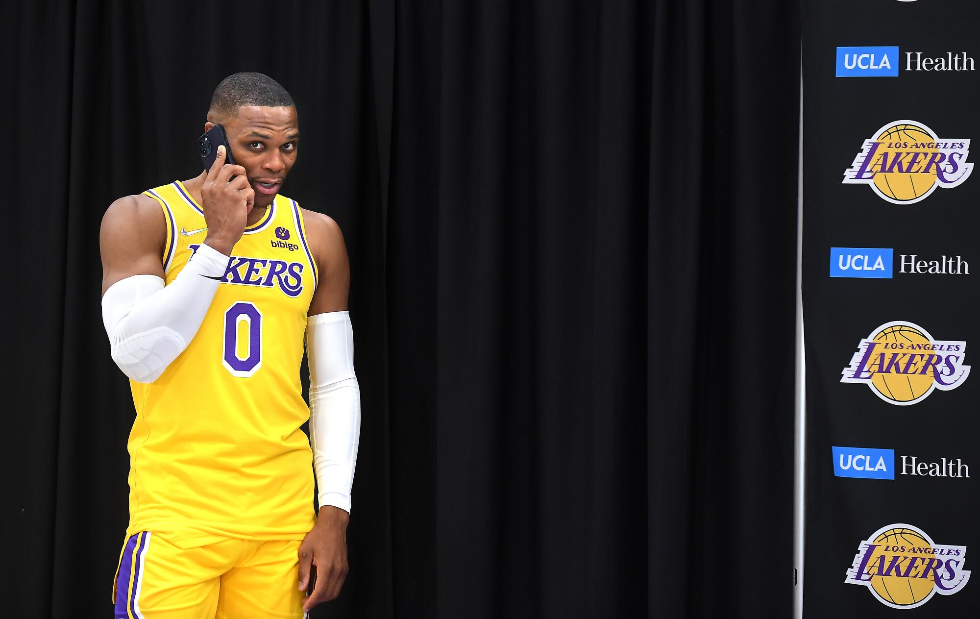 Lakers Russell Westbrook talks on the phone before an interview during media day.
