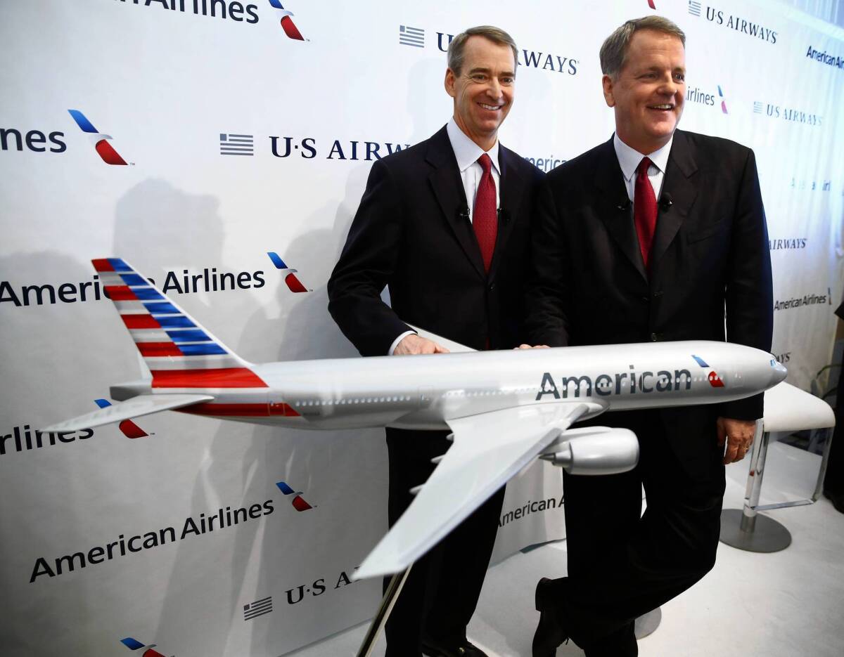 American Airlines CEO Tom Horton, left, and US Airways CEO Doug Parker appear with an airplane model bearing the new American Airlines logo after announcing the two airlines' merger at Dallas-Fort Worth International Airport
