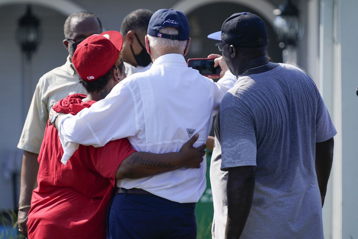President Joe Biden takes a photo with residents as he tours a neighborhood impacted by Hurricane Ida, Friday, Sept. 3, 2021, in LaPlace, La. (AP Photo/Evan Vucci)