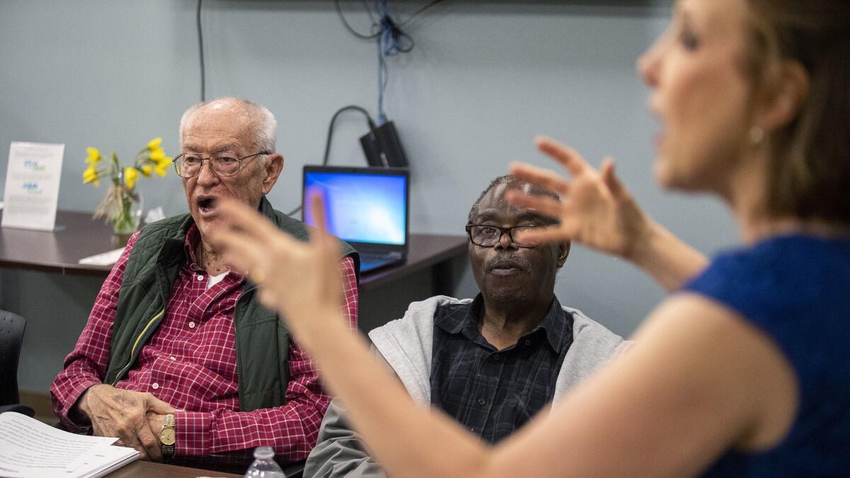 Parkinson’s disease patients Mark Curley, left, and Samuel Sebabi work on their speech during a therapy session directed by Samantha Elandary on March 13.