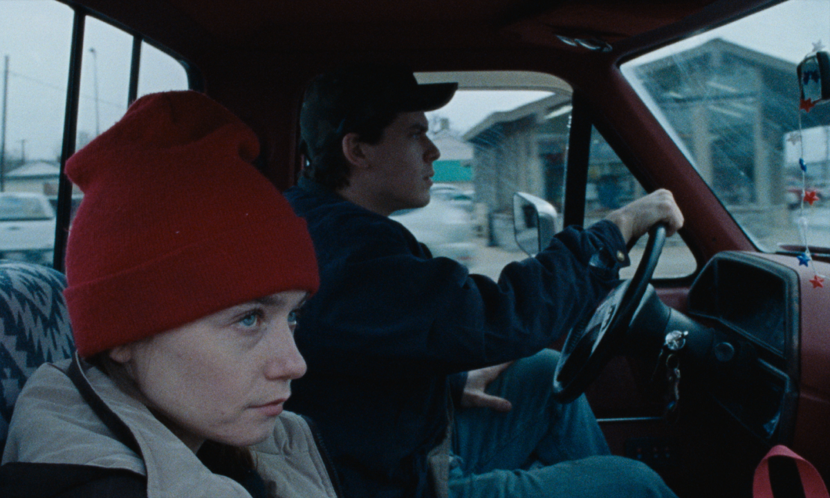 A young woman and a young man in a pickup cab.