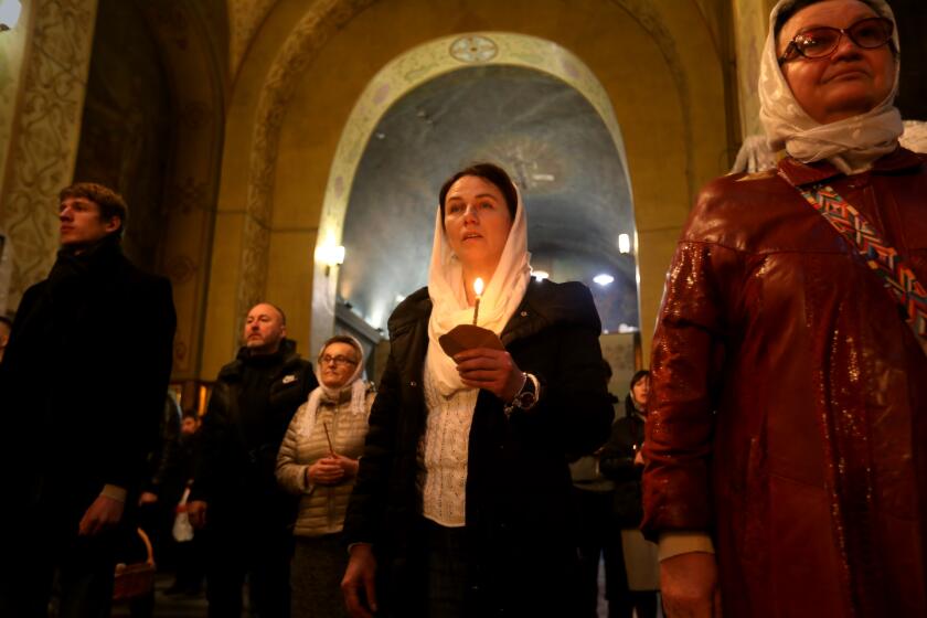 DNIPRO, UKRAINE-APRIL 24, 2022-In Dnipro, hundreds of worshipers gathered at dawn, at the end of curfew, to celebrate Orthodox Christian Easter at Troitska Church on April 24, 2022. They brought Easter baskets filled with baked goods, fruit and candles. (Carolyn Cole / Los Angeles Times)