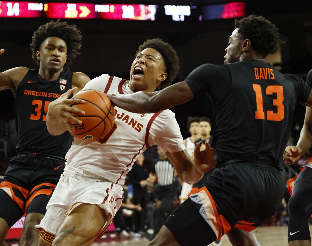 USC guard Boogie Ellis is fouled by Oregon State Beavers guard Dashawn Davis as he drives to the basket.