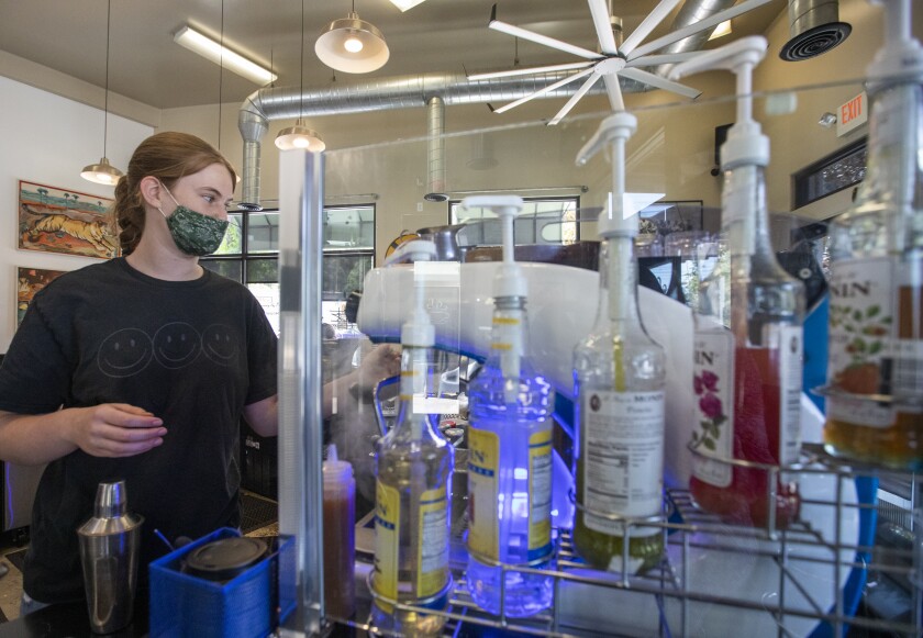 A barista wears a face mask at work.