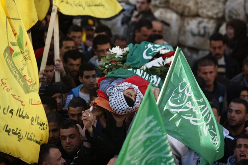 Palestinians carry the body of the 17-year-old Samir Awad during his funeral in the West Bank village of Budrus on Tuesday.
