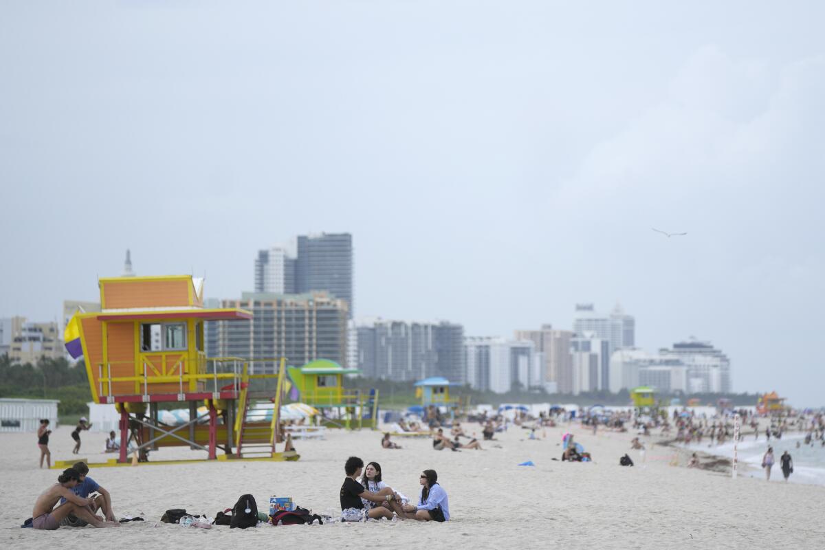 People sit on the beach in Miami.