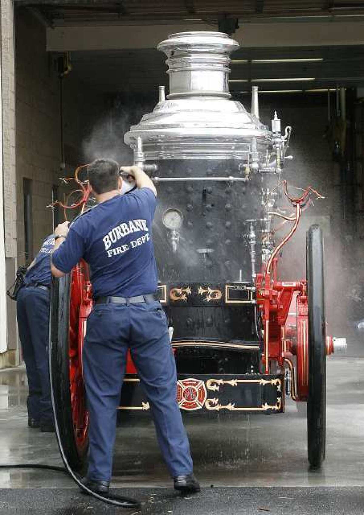 Burbank firefighters clean a working 1915 Christie Steamer on Monday, April 15, 2013, in preparation for Fire Service Day in May. The steamer will be demonstrated during the family-friendly day.