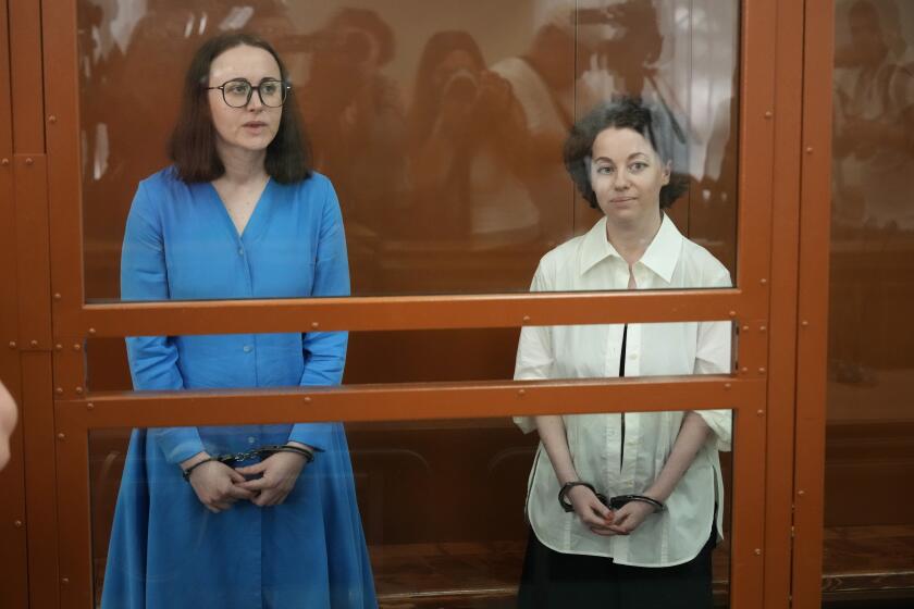 La directora de teatro Zhenya Berkovich (d) y la dramaturga Svetlana Petriychuk en una jaula de vidrio previo a una audiencia en un tribunal de Moscú el 8 de julio del 2024. (Foto AP /Alexander Zemlianichenko)