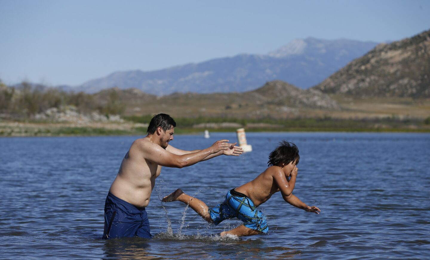 Abe Quirarte tosses his son, Abe Jr., 8, of San Gabriel, as they cool off at Lake Perris in Riverside County amid high temperatures Thursday.