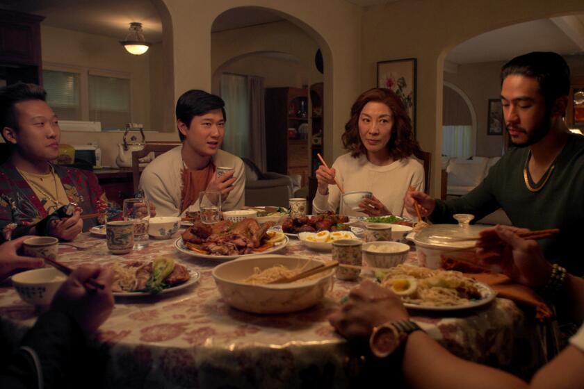 An Asian family sitting around a circular table eating dinner.